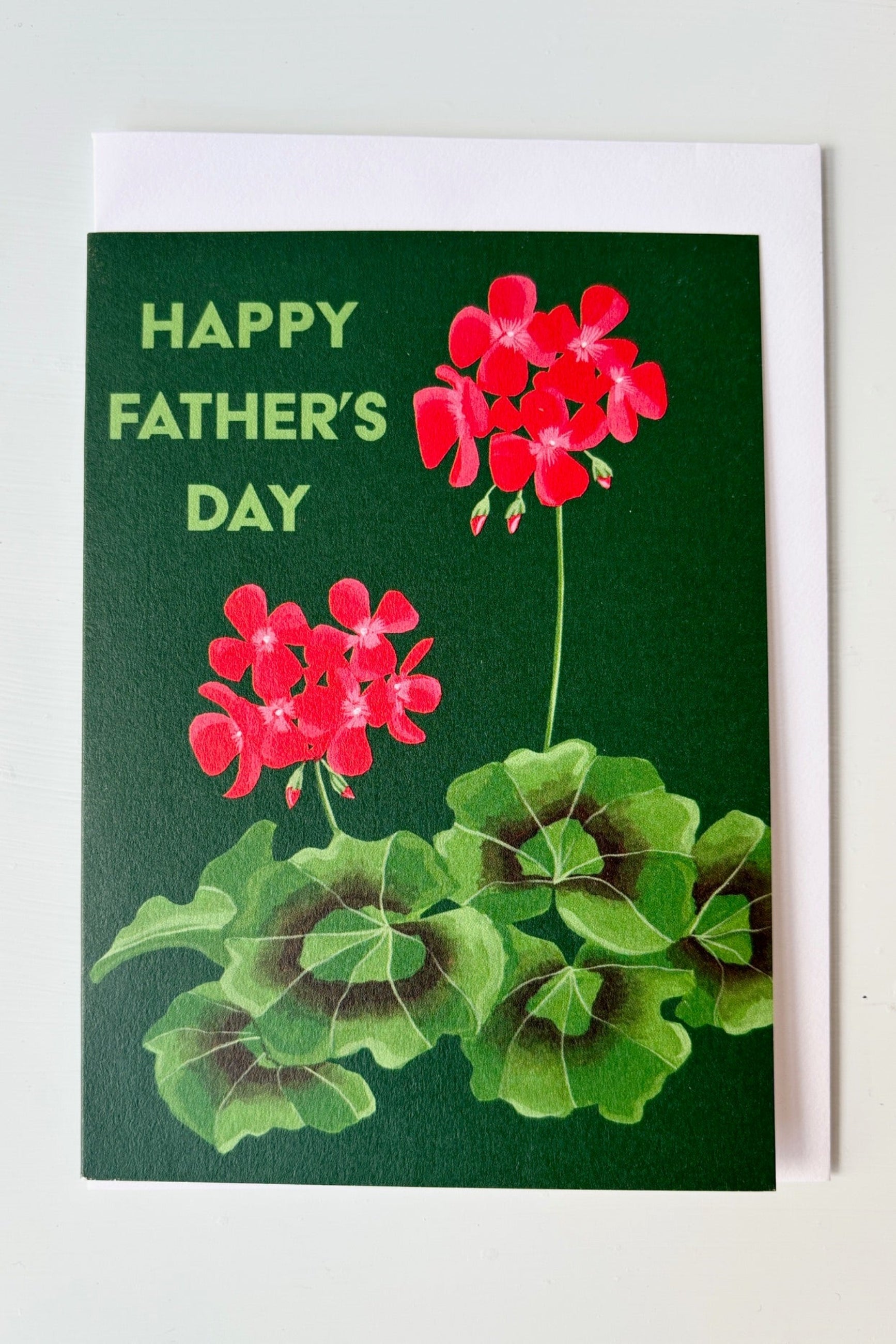 Greeting card with image of red flowering zonal begonia with text that says Happy Father's Day on a green background ©Sprout Home