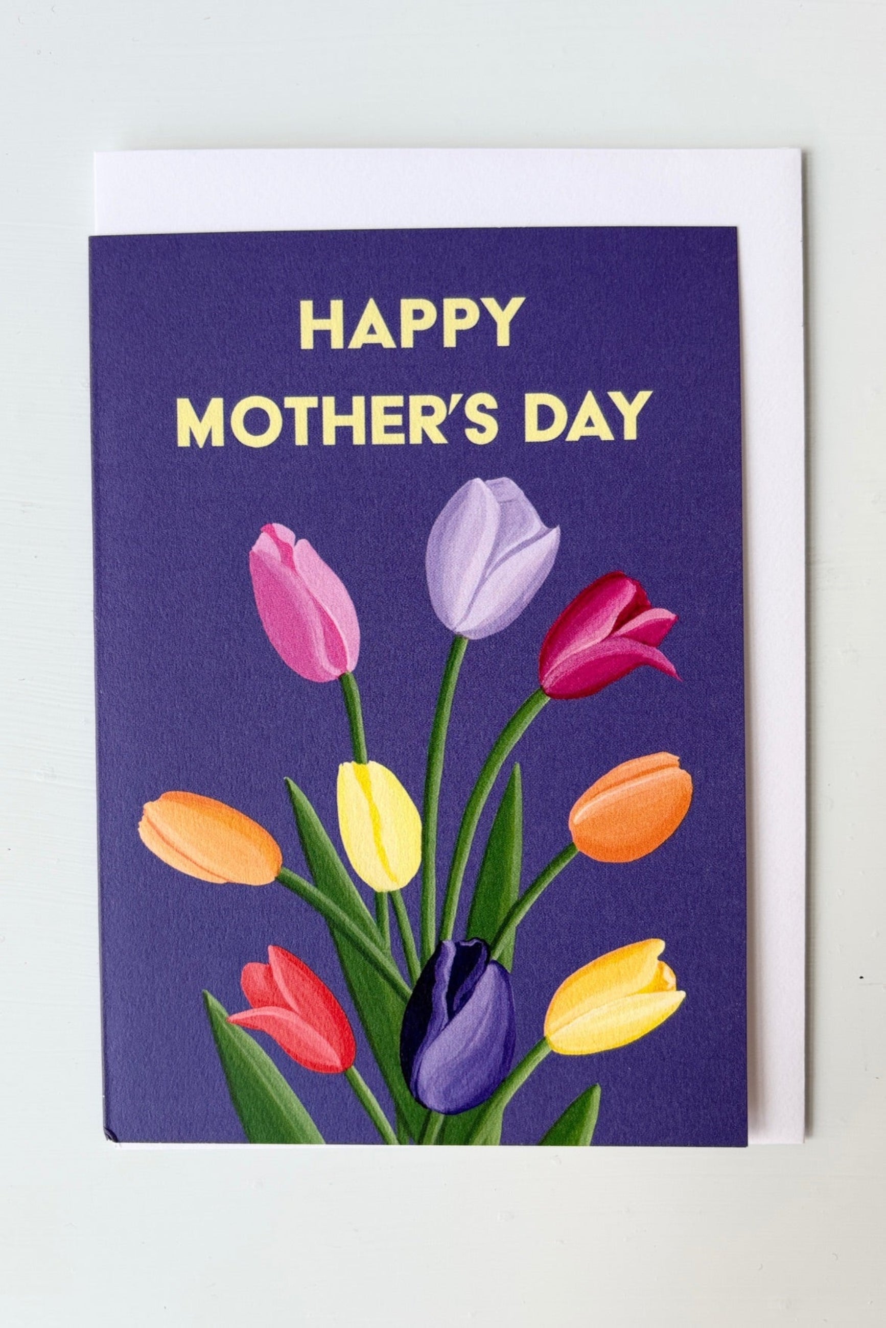 Greeting card with multicolored tulips on a purple background with the text Happy Mother's Day shown with envelope ©Sprout Home
