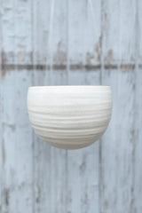 The creamy white speckle finish Spherical Hanging Planter hanging empty and viewed from the side