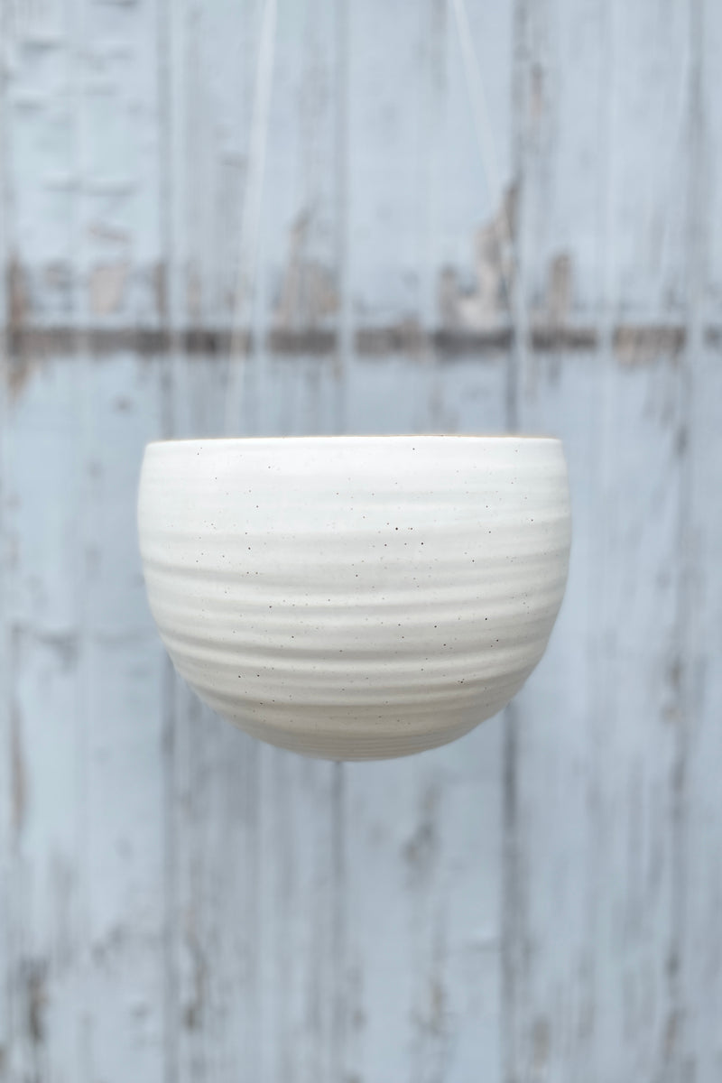 The creamy white speckle finish Spherical Hanging Planter hanging empty and viewed from the side