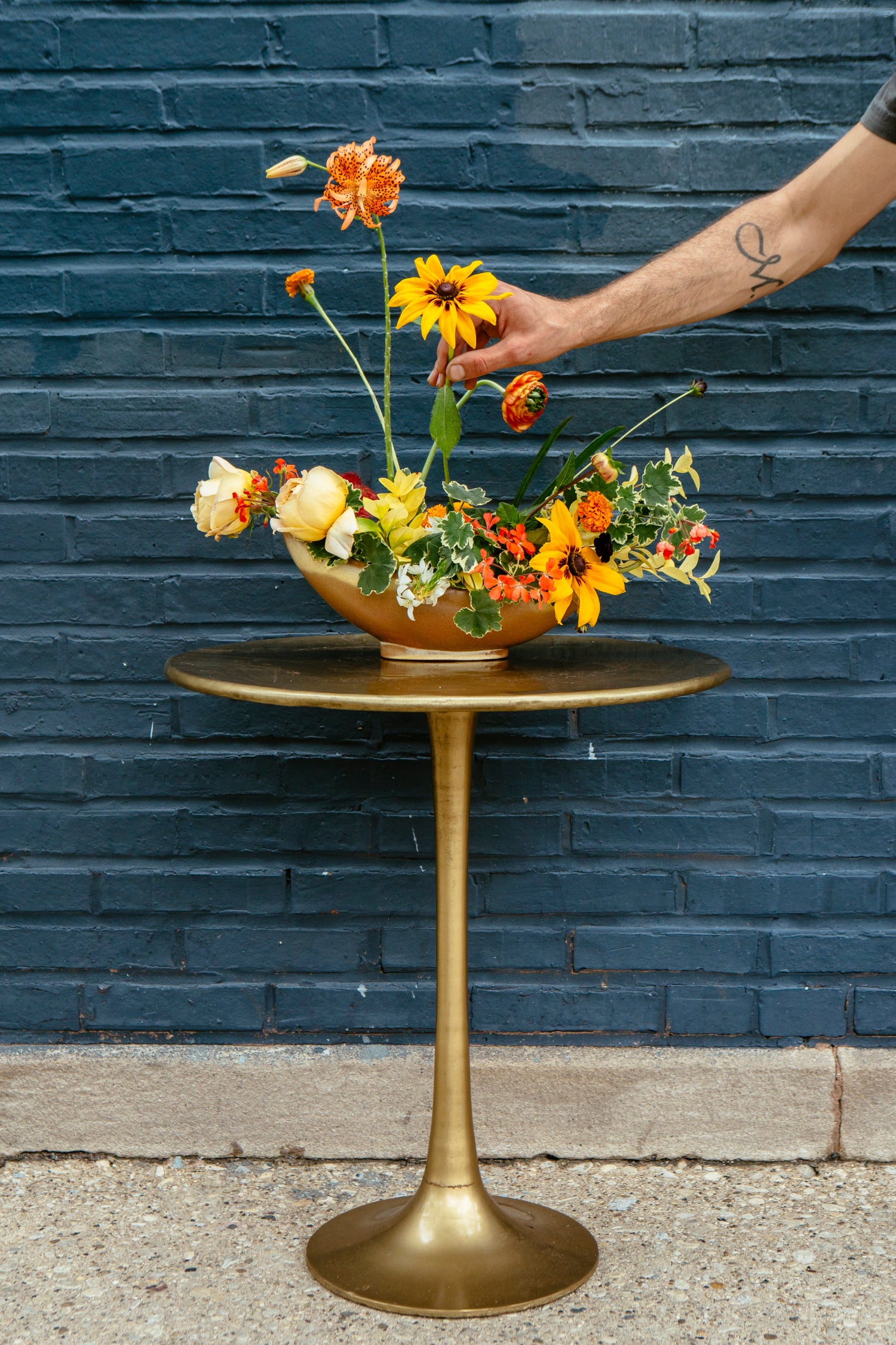 Warm floral arrangement in a low copper bowl in front of Bar Deville in Chicago. Floral by SPROUT HOME. Photo by Heather Talbert