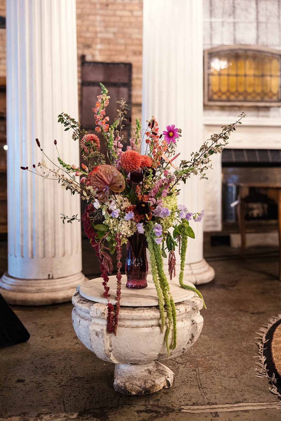 Floral arrangement in a decorative urn against a classical architecture background at a wedding at Salvage One in Chicago where Sprout Home did the floral for the bride and groom ©Emma Mullins Photography
