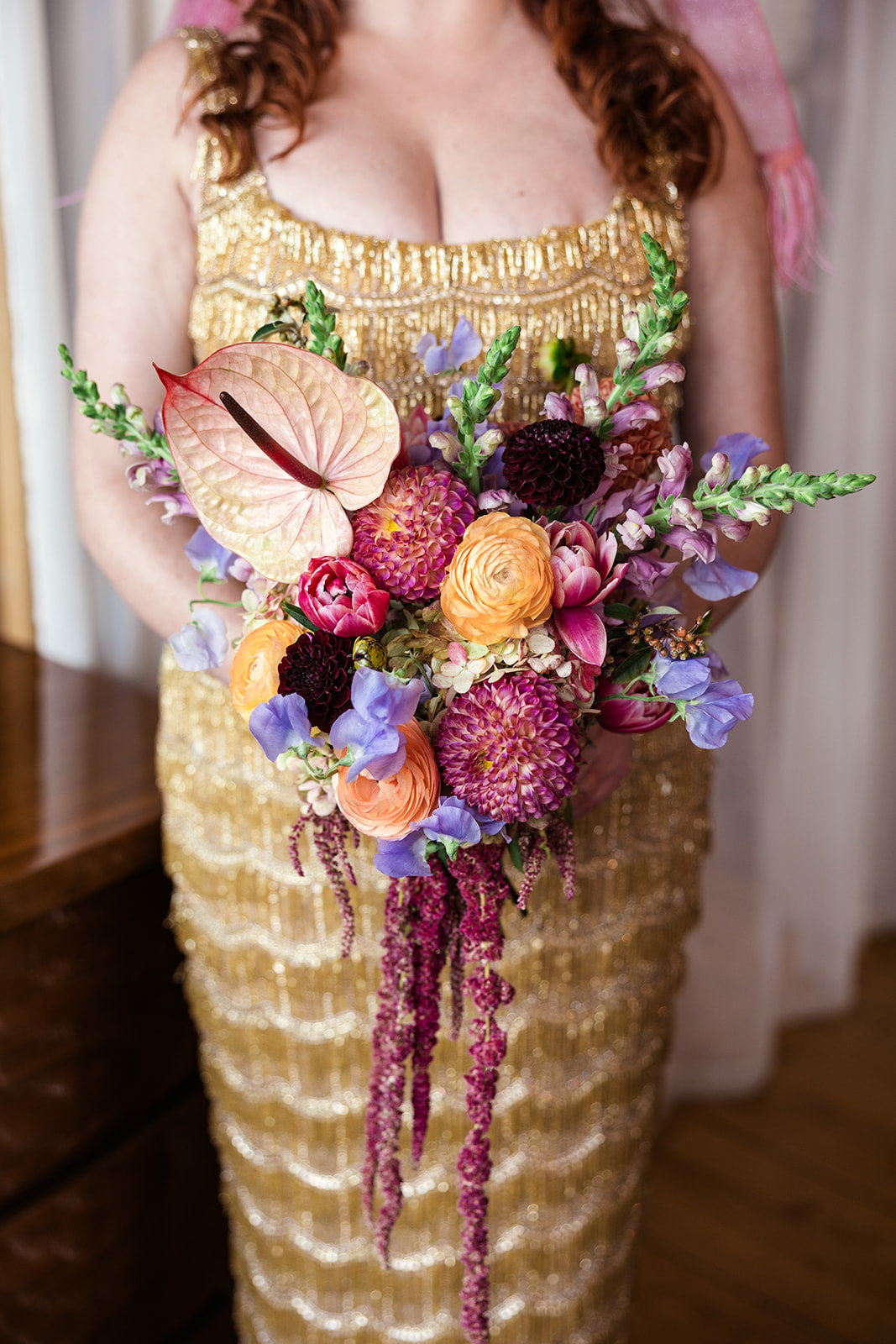 Bride wearing a gold dress holding a colorful bouquet of flowers by Sprout Home for their wedding at Salvage One in Chicago©Emma mullins photography