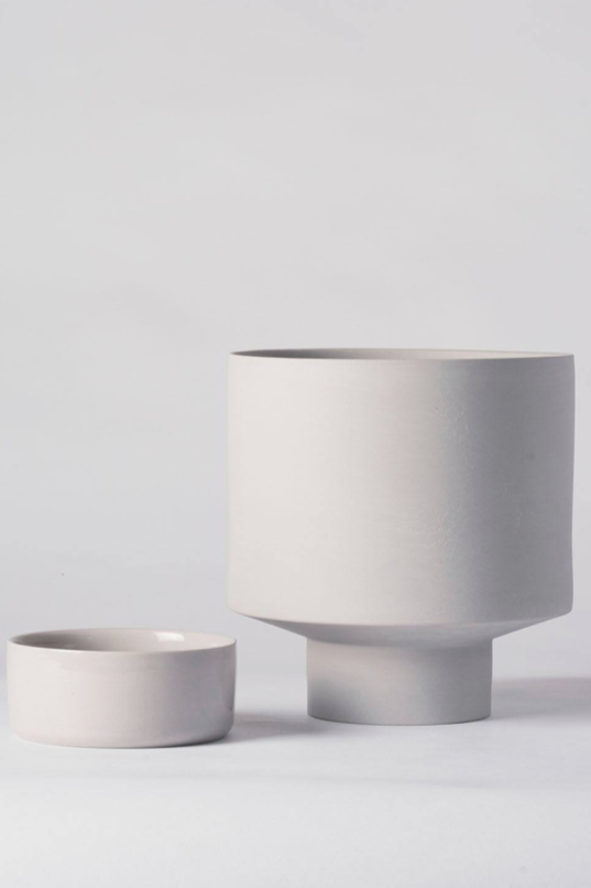 A light grey Collector's Gro pot by Angus & Celeste being shown with its detachable saucer to the side of the pot.