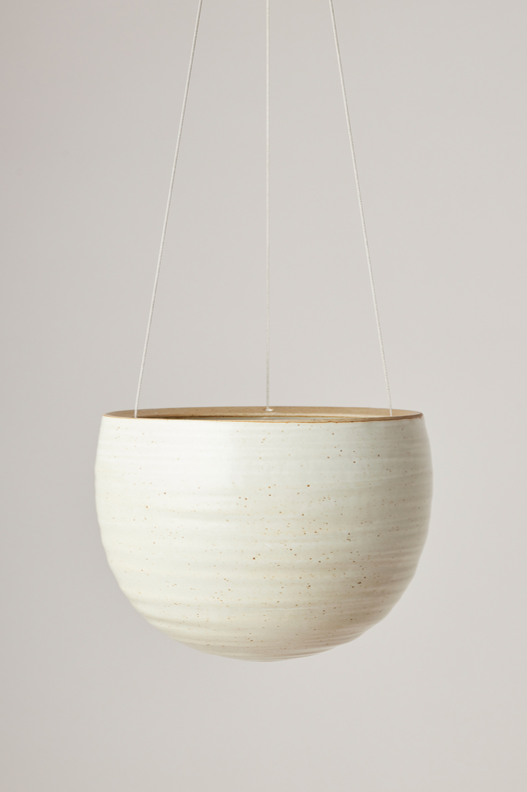 Spherical Hanging Planter
Creamy White Speckle
by Angus & Celeste hanging and empty against a white wall. 