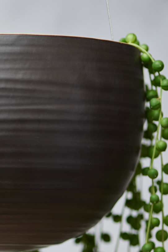 Spherical Hanging Planter
Smooth Matt Black by Angus & Celeste showing it up close with a string of pearls inside and the smooth black finish of the glaze.