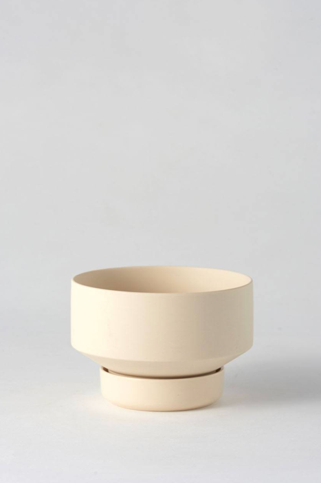 Clay colored Collector's Gro Pot from Angus & Celeste being shown empty and against a white wall. 