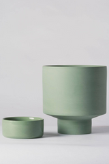 An olive green Collector's Gro Pot from Angus & Celeste being shown with its drain tray separated and to the side. 