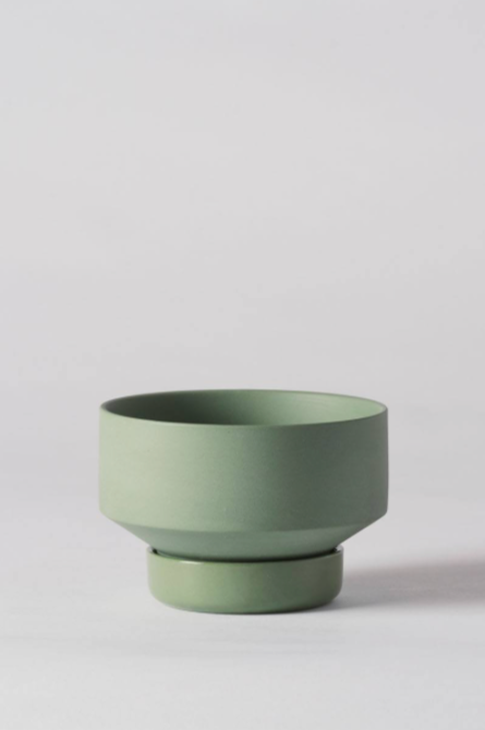 A small Olive Green Collector's Gro pot by Angus & Celeste empty and against a white wall. 