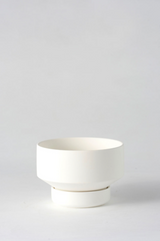 The small white Collector's Gro Pot by Angus & Celeste shown empty and against a white wall. 