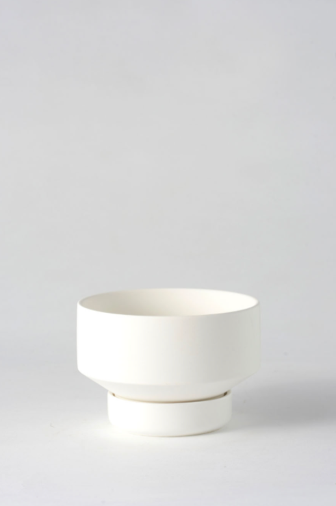 The small white Collector's Gro Pot by Angus & Celeste shown empty and against a white wall. 