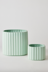 A Mint Modular Stack Planter by Angus & Celeste shown empty and the main pot and reservoir pot standing separate from one another. 