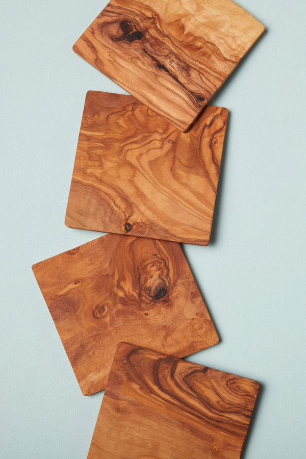 set of 4 olive wood coasters shown fanned out vertically.