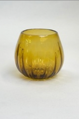 Amber pleated glass shown on an off-white background.