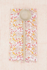 Suzette Frangipanier Jaipur napkin folded in to a rectangle, wood spoon on top and on a striped background. 