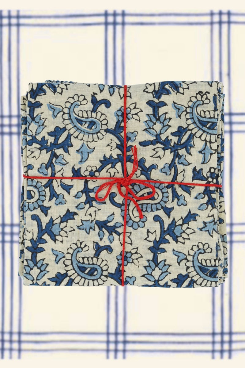 Suzette Cotton Napkins Pourpier Cobalt tied with a red string on a blue and white checked linen.