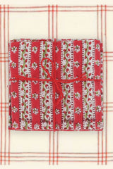 Suzette Cotton Napkins Sweet Pea tied with a red ribbon and a cream and white plaid textile behind the