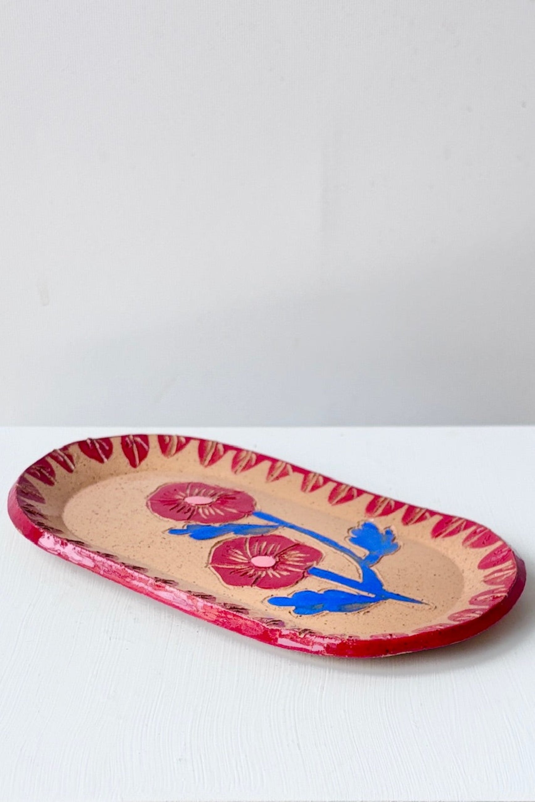 Decorative Red & Blue Blossom Sgraffito Dish ceramic plate with floral design on a white table ©Sprout Home