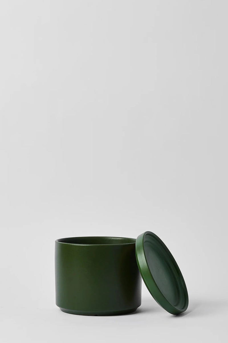 LBE Design Solid Goods Cylinder with Saucer in forest green with its saucer leaning against the pot.