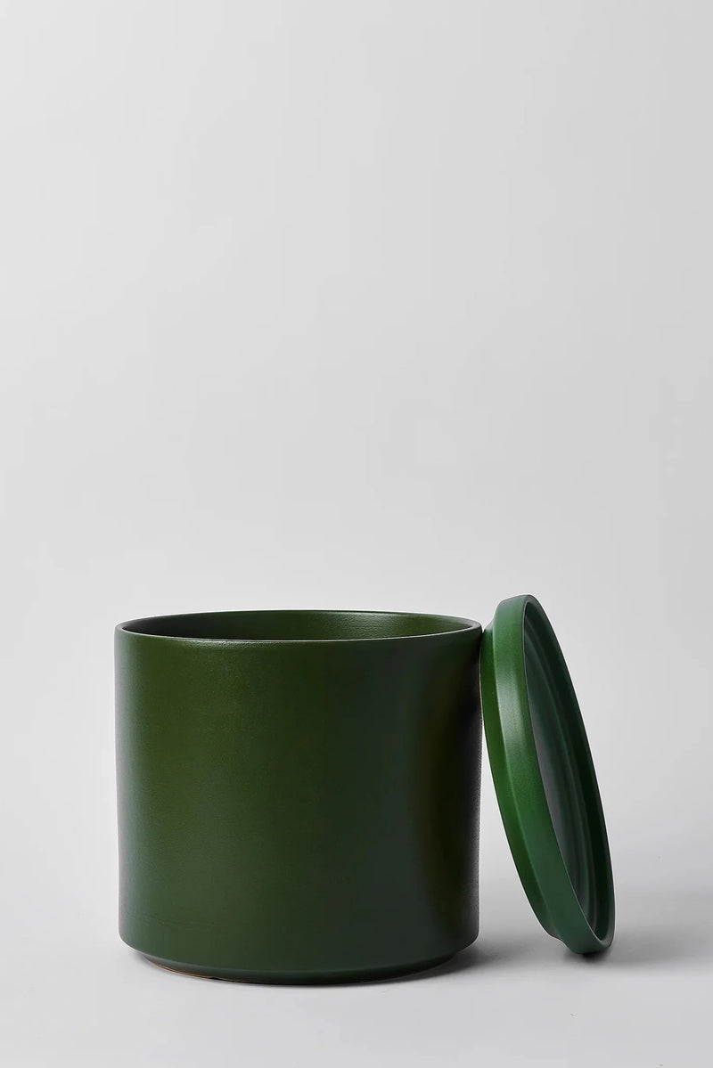 LBE Design Solid Goods Ceramic Cylinder planter and saucer in Forest Green shown with its saucer leaning against the main pot