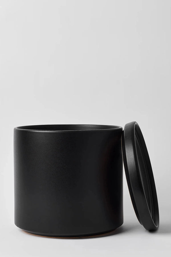 LBE Design Solid Goods Planter and saucer in black with its saucer leaned up against the empty planter