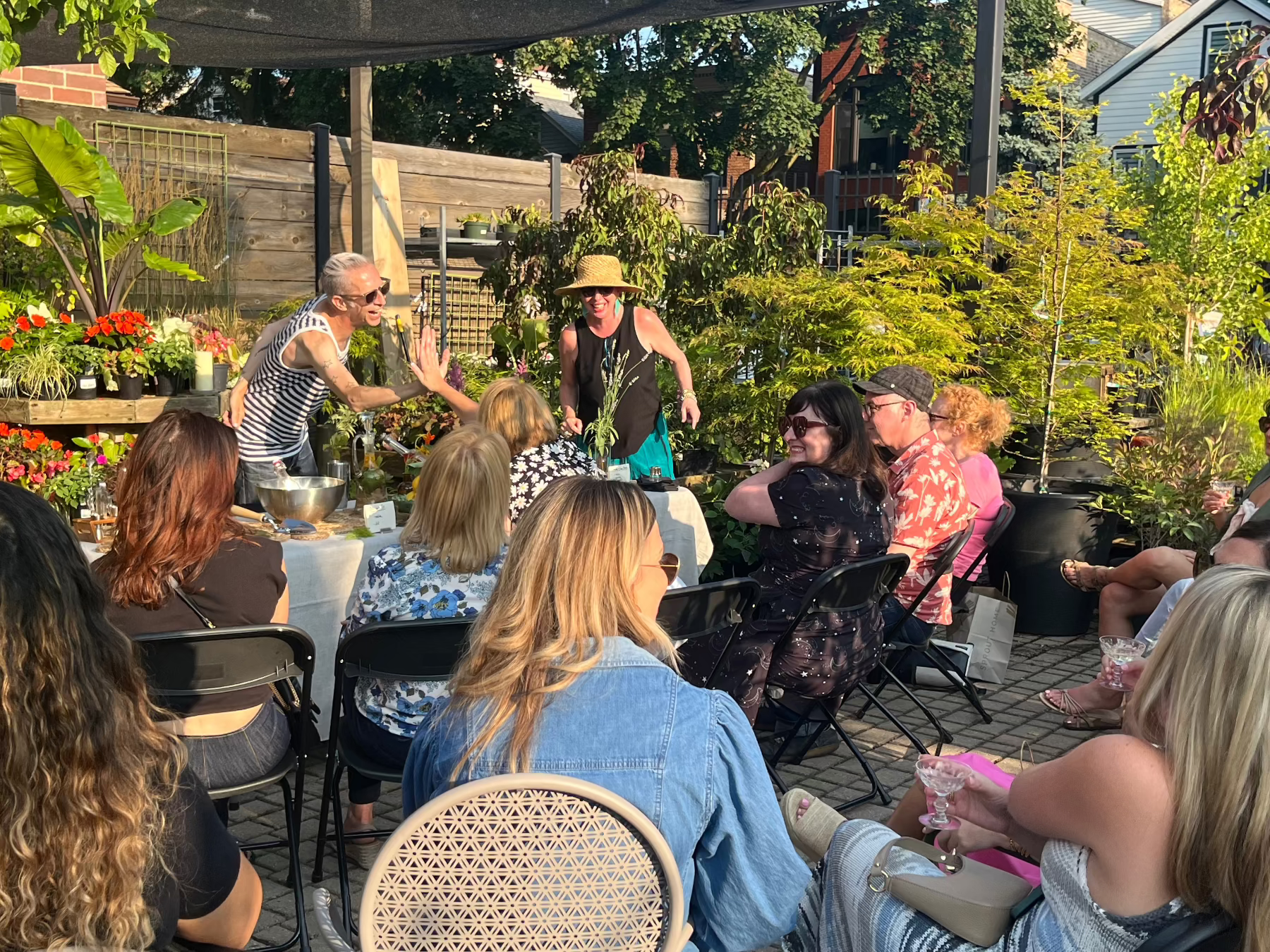 A group of people attending a SPROUT HOME class with Heritage restaurant in the summer outside.