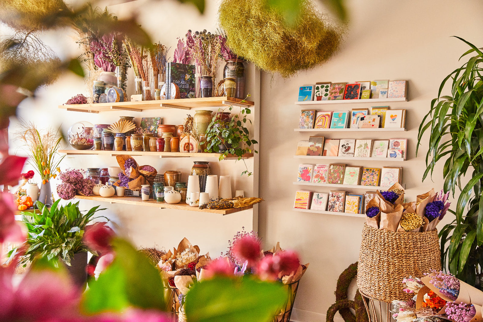 Inside the floral store at SPROUT HOME with product shelves in the background and floral in the foreground. 