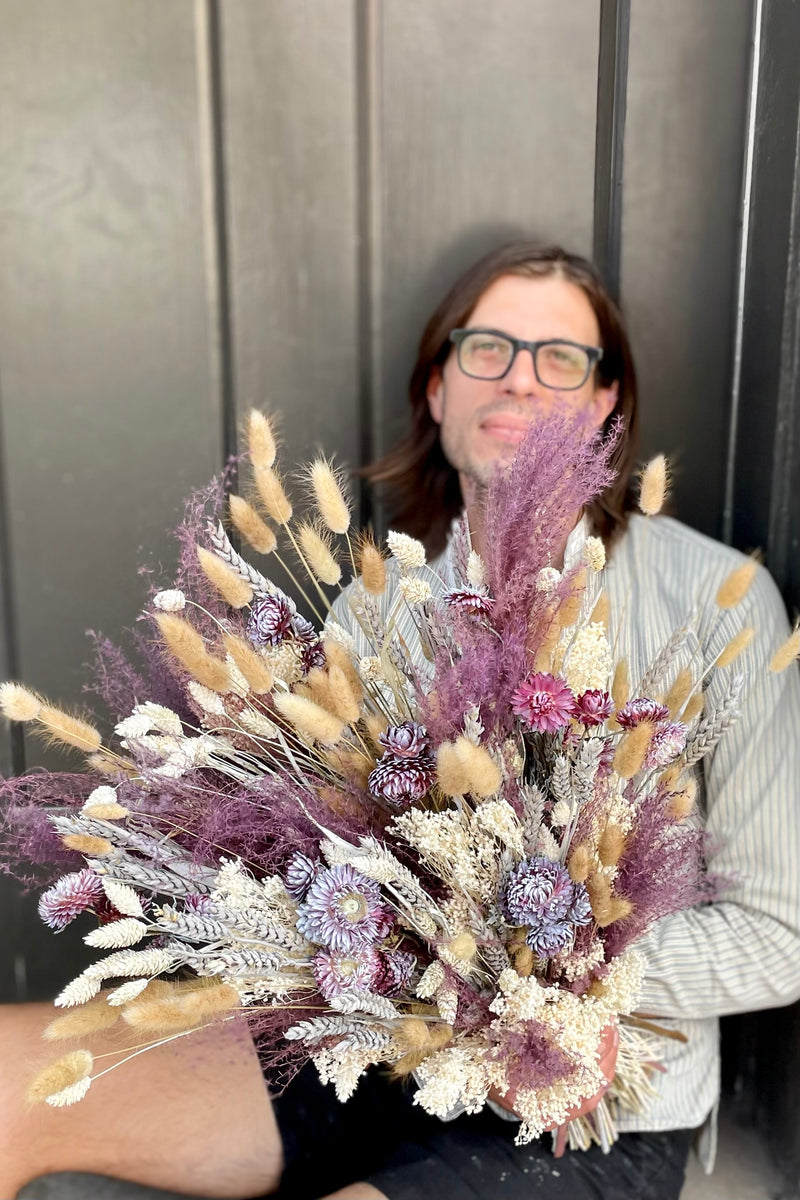 Stardust arrangement being held by Sprout Home's Stephen sitting in a doorway