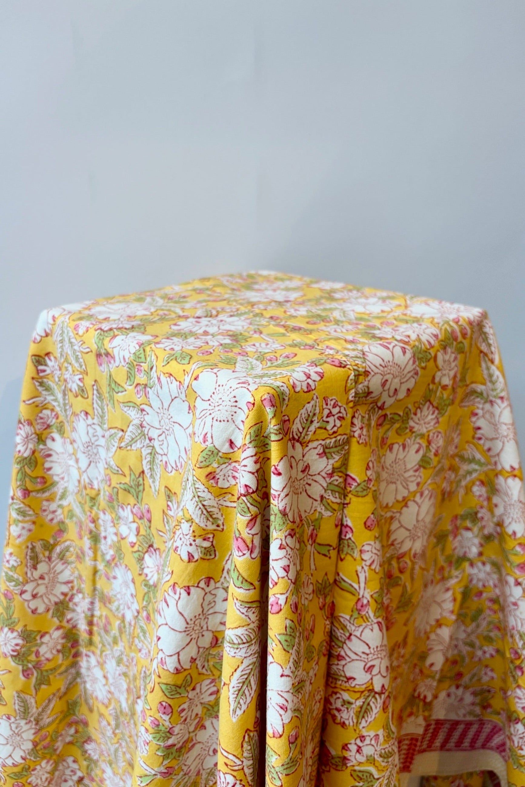 Hand printed, 100% cotton Camelia yellow and pink tablecloth on table ©Sprout Home