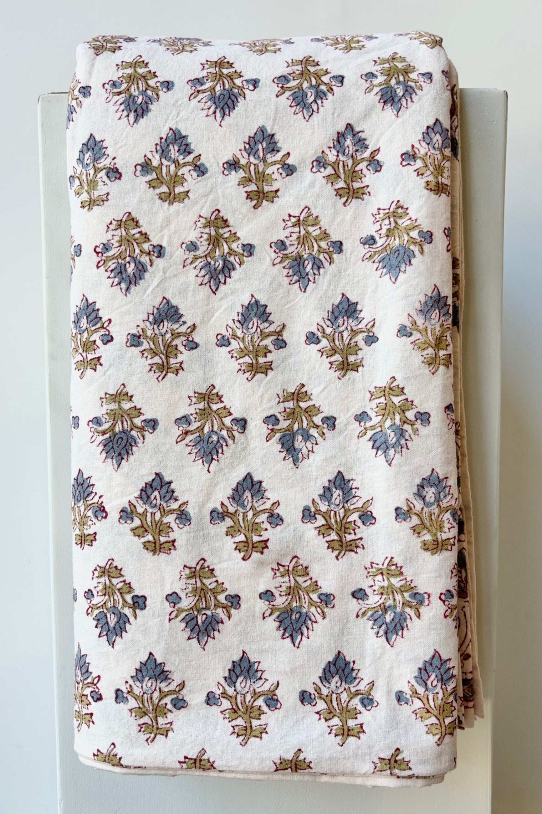 Hand printed Silvia tablecloth with blue and green filagree floral design on a white background ©Sprout Home