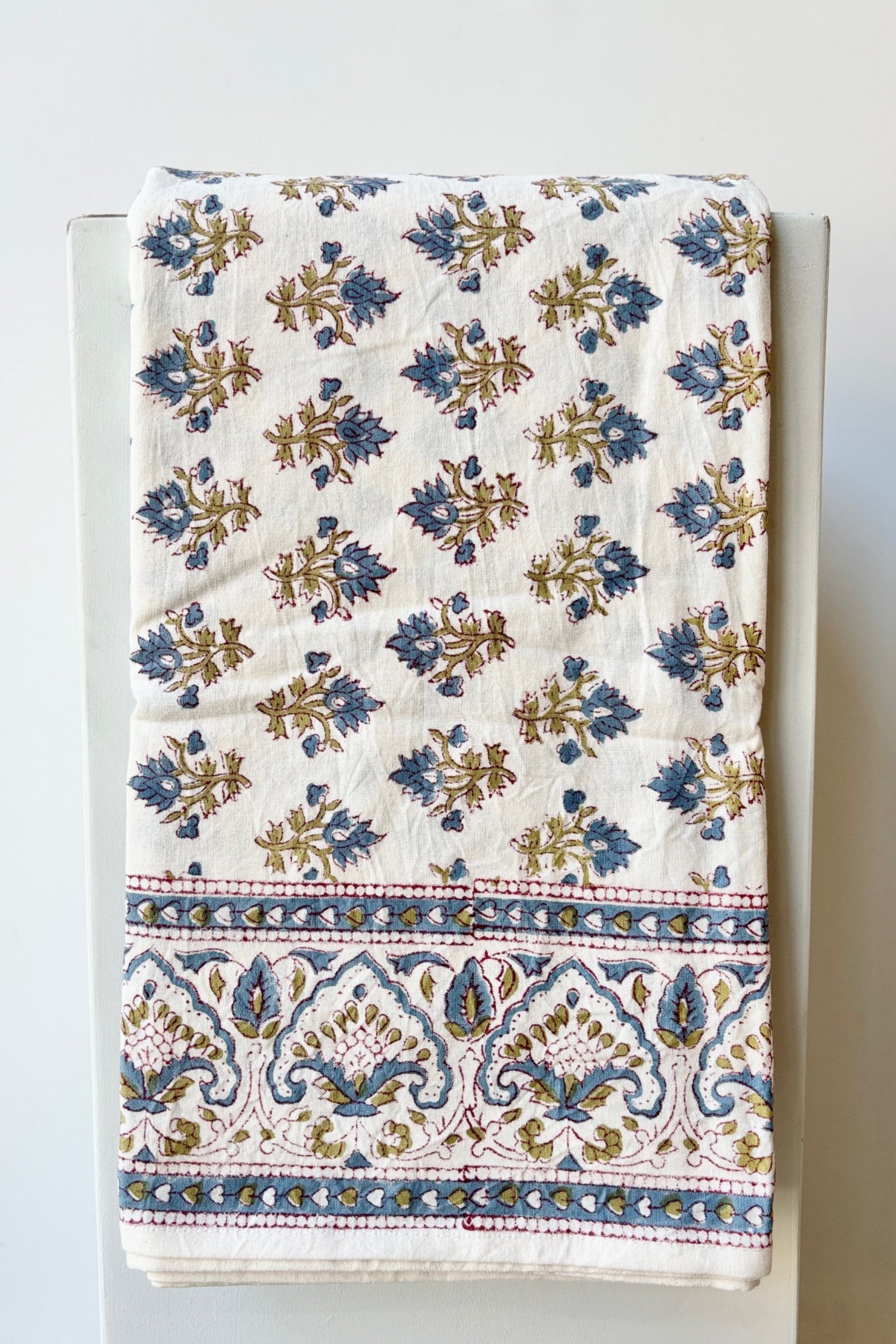 Hand printed Silvia tablecloth with blue and green filagree floral design on a white background ©Sprout Home