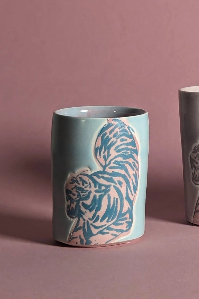 Ceramic cup with animal pattern on a pink background focusing on the Blue Pink shot glass in particular ©City in Bloom Ceramics