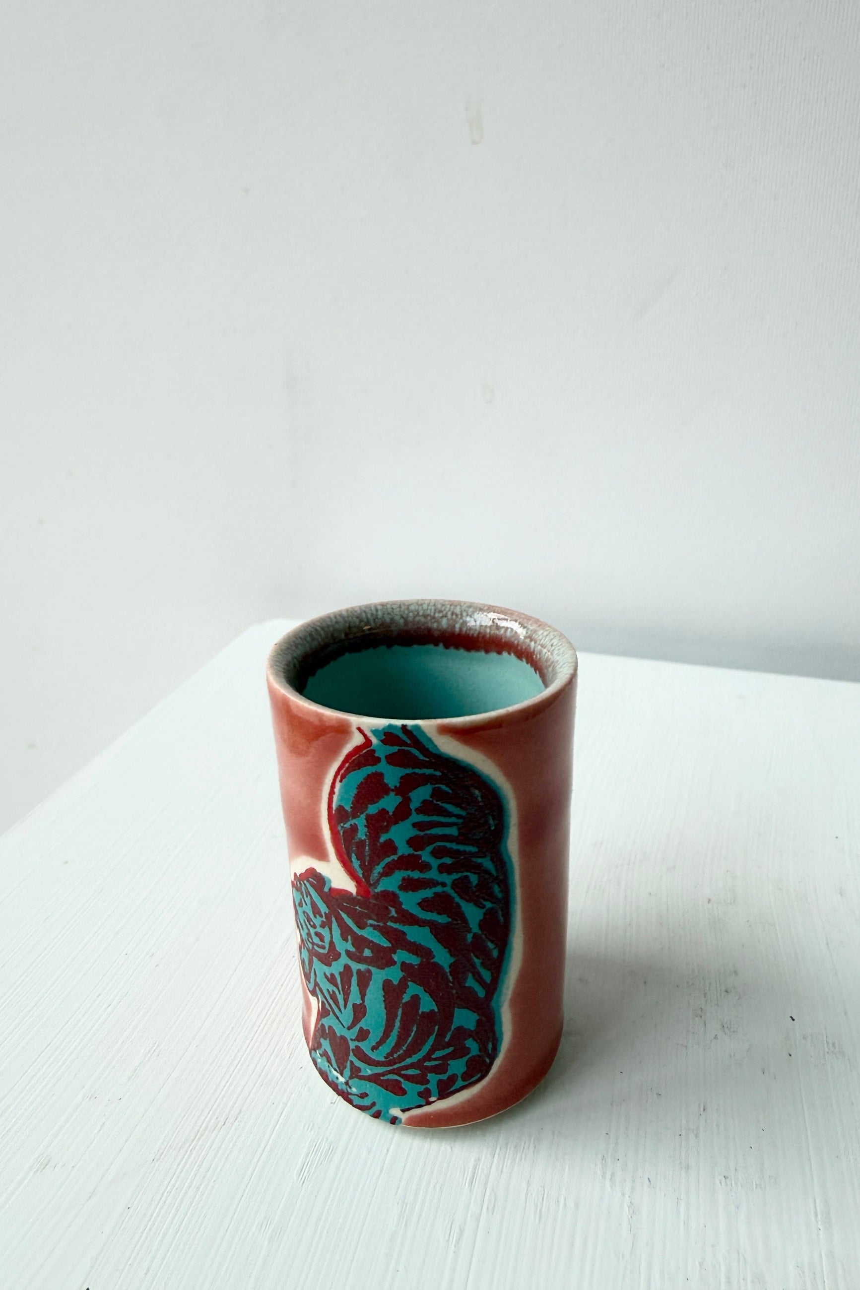 Tiger Shot class in red teal by City in Bloom Ceramis on a white surface ©Sprout Home