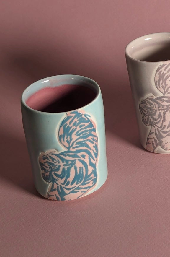 Ceramic cup with animal pattern on a pink background focusing on the Blue Pink shot glass in particular ©City in Bloom Ceramics