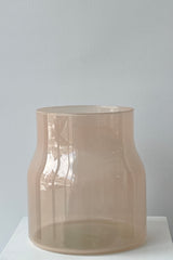 Photo of tinted glass of Bodii Vase against a white wall.