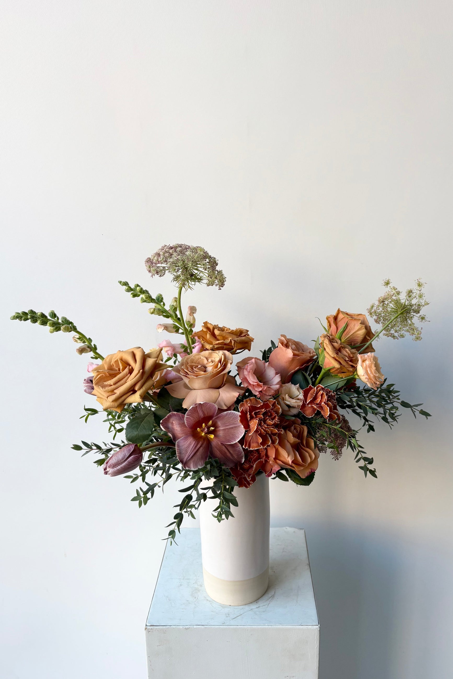 A floral arrangement in a white vase with dyed dianthus and dyed tulips in late winter by Sprout Home ©Sprout Home #size_$130