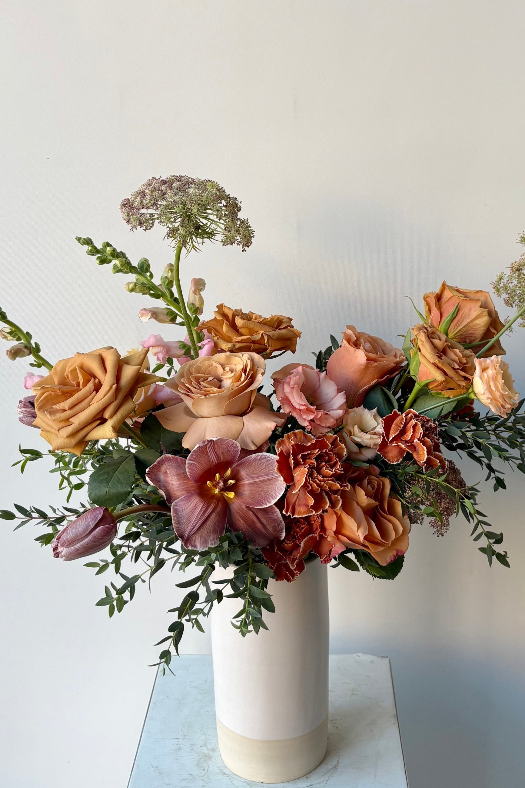 A floral arrangement in a white vase with dyed dianthus and dyed tulips in late winter by Sprout Home ©Sprout Home #size_$130
