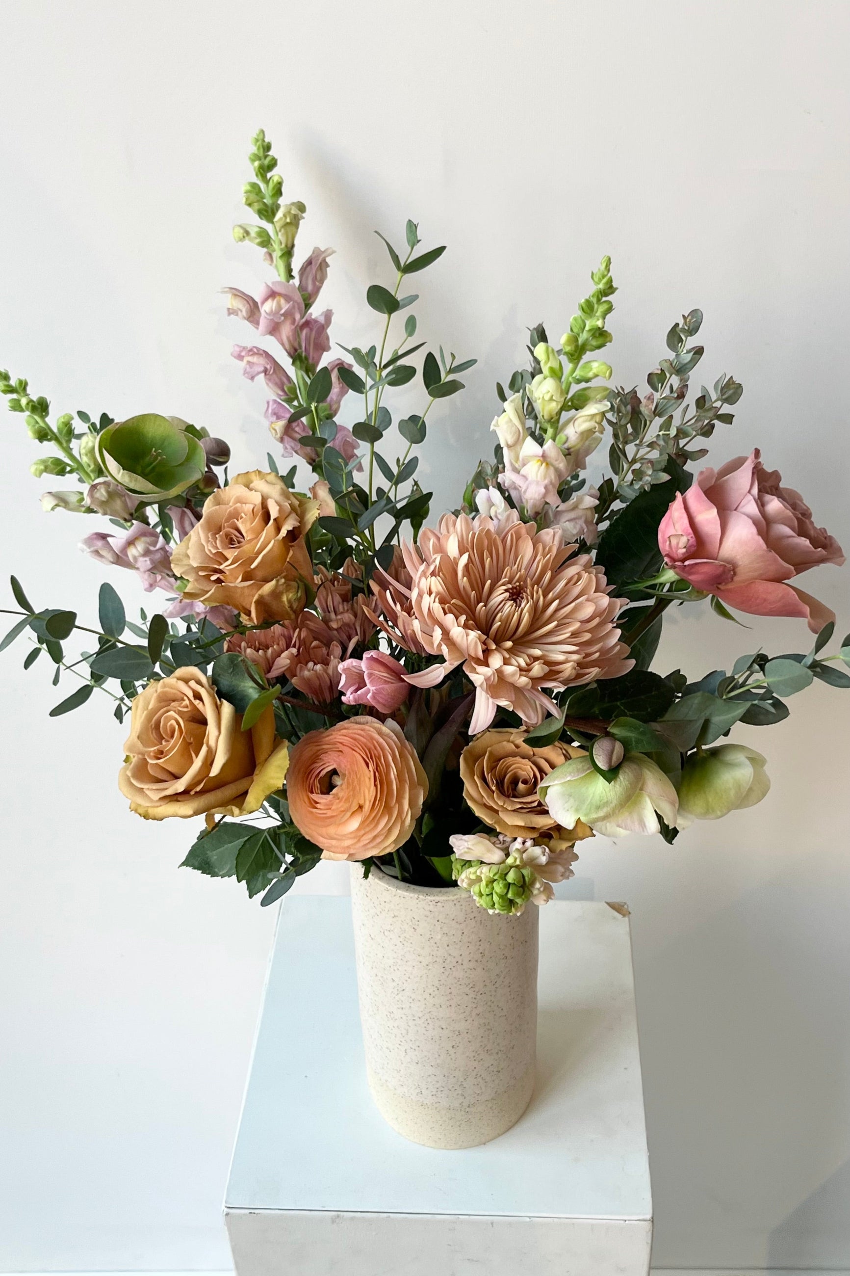 A bouquet in a white vase with caramel and bronze colors roses and ranunculus in late winter ©Sprout Home #size_$100