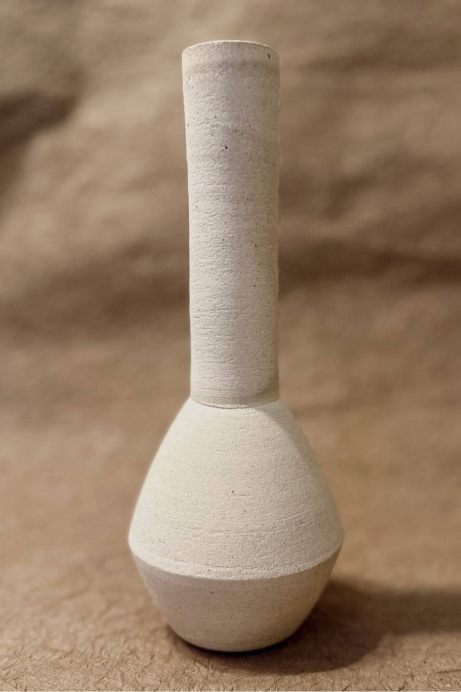 A tall narrow ceramic bud vase on a neutral background ©Olivia Snow Ceramics
