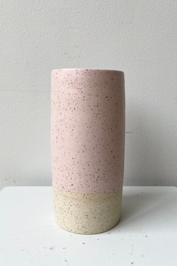 Small Jacqueline vase in Pink Speckle against a white wall. 