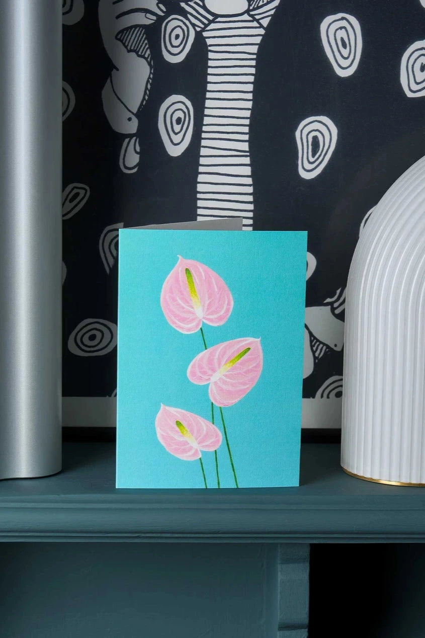 Anthuriums greeting card by Stengun Drawings on a shelf with graphic black and white wallpaper.