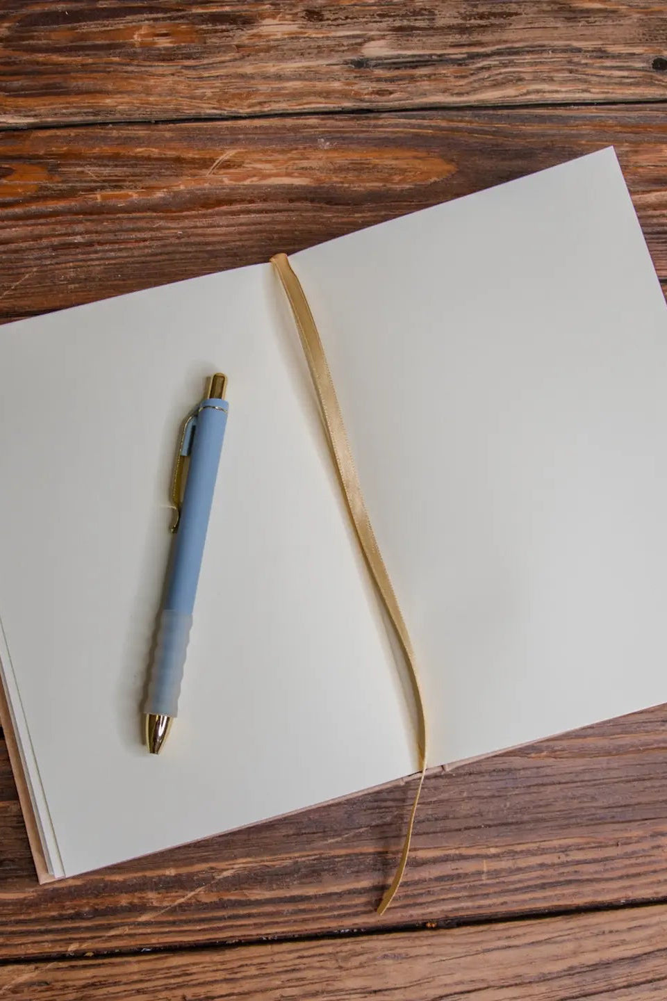 Open notebook with a pen on a wooden surface ©Glum Lot Press