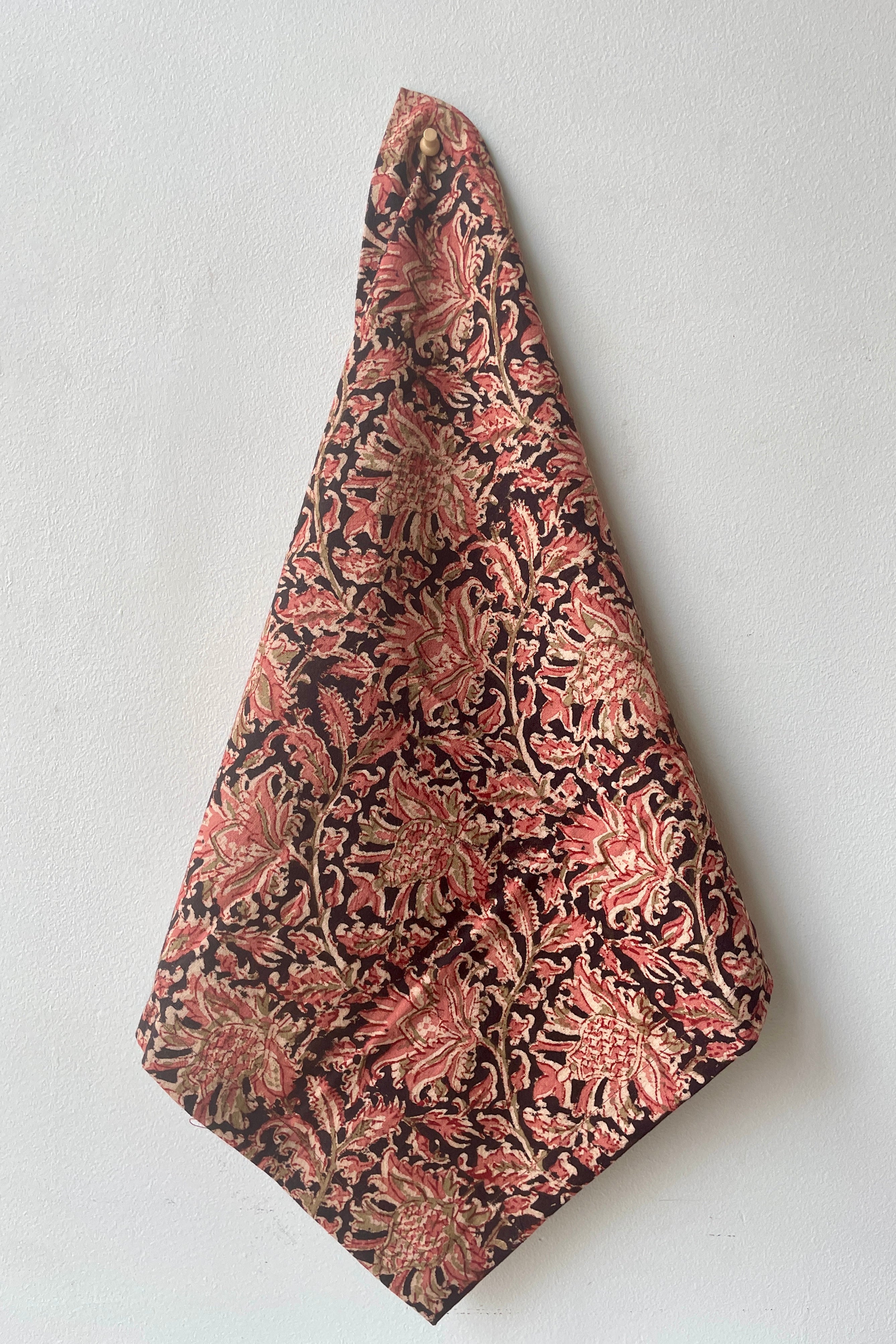 The Adah napkin kesar hanging against a white wall.