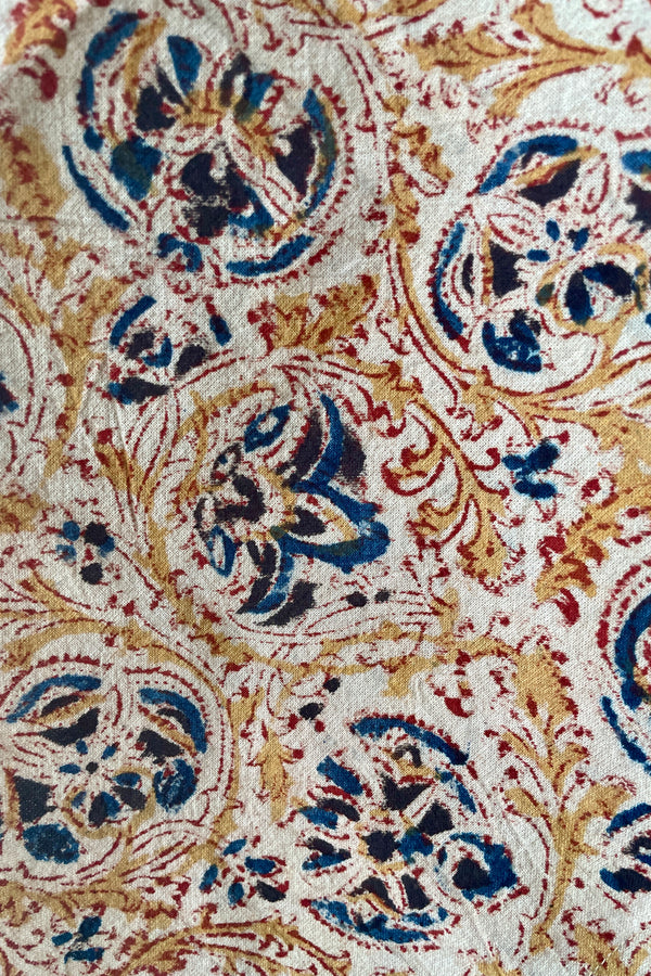 A detail picture of the blue, gold, white and burgundy floral. motif on the fabric. 