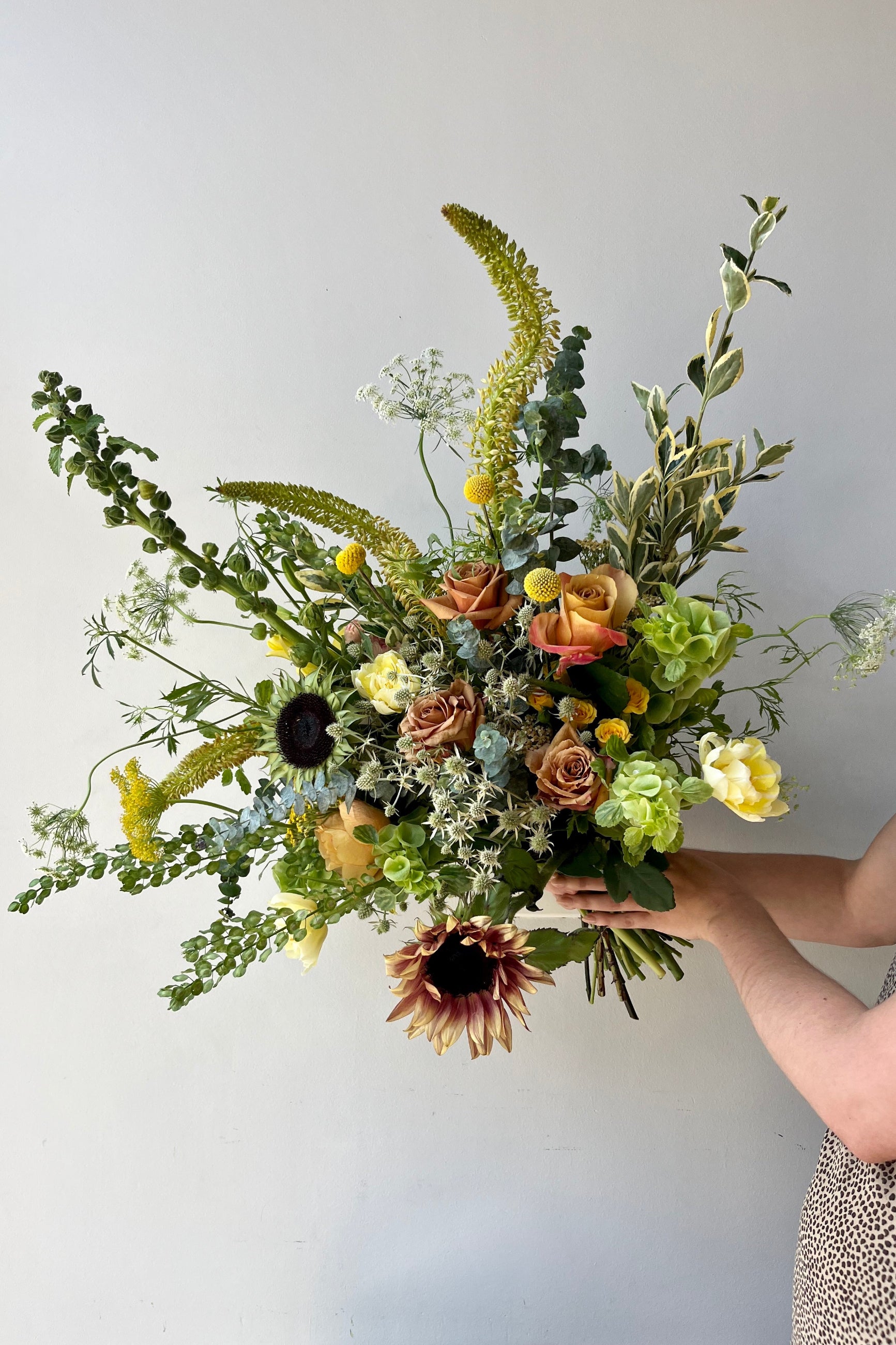 Custom August Champagne Toast arrangement by Sprout Home featuring sunflowers and eremerus. ©Sprout Home #size_$160 