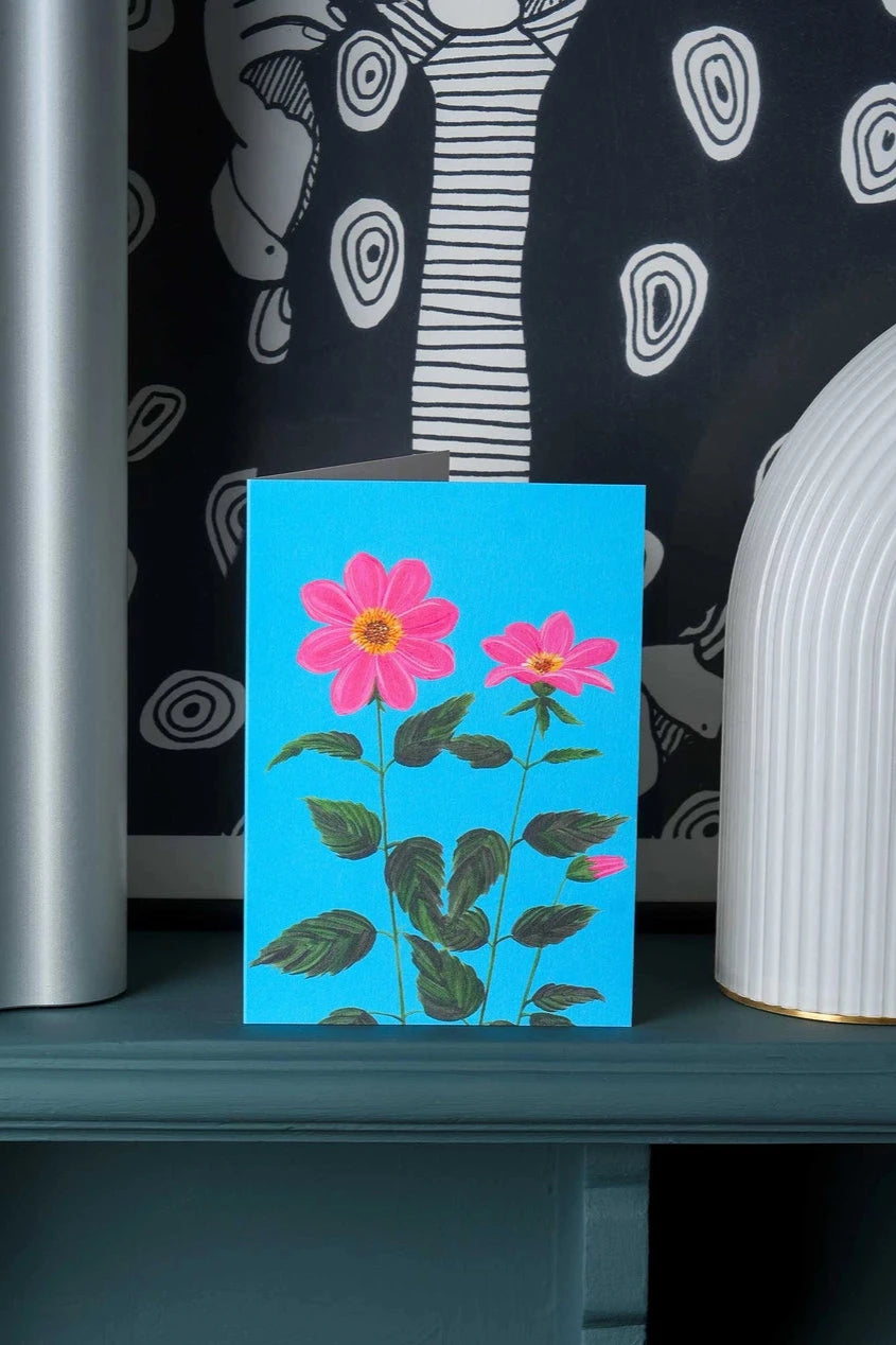 Dahlia greeting card by Stengun Drawings on a shelf with a black and white abstraction on the wall. 