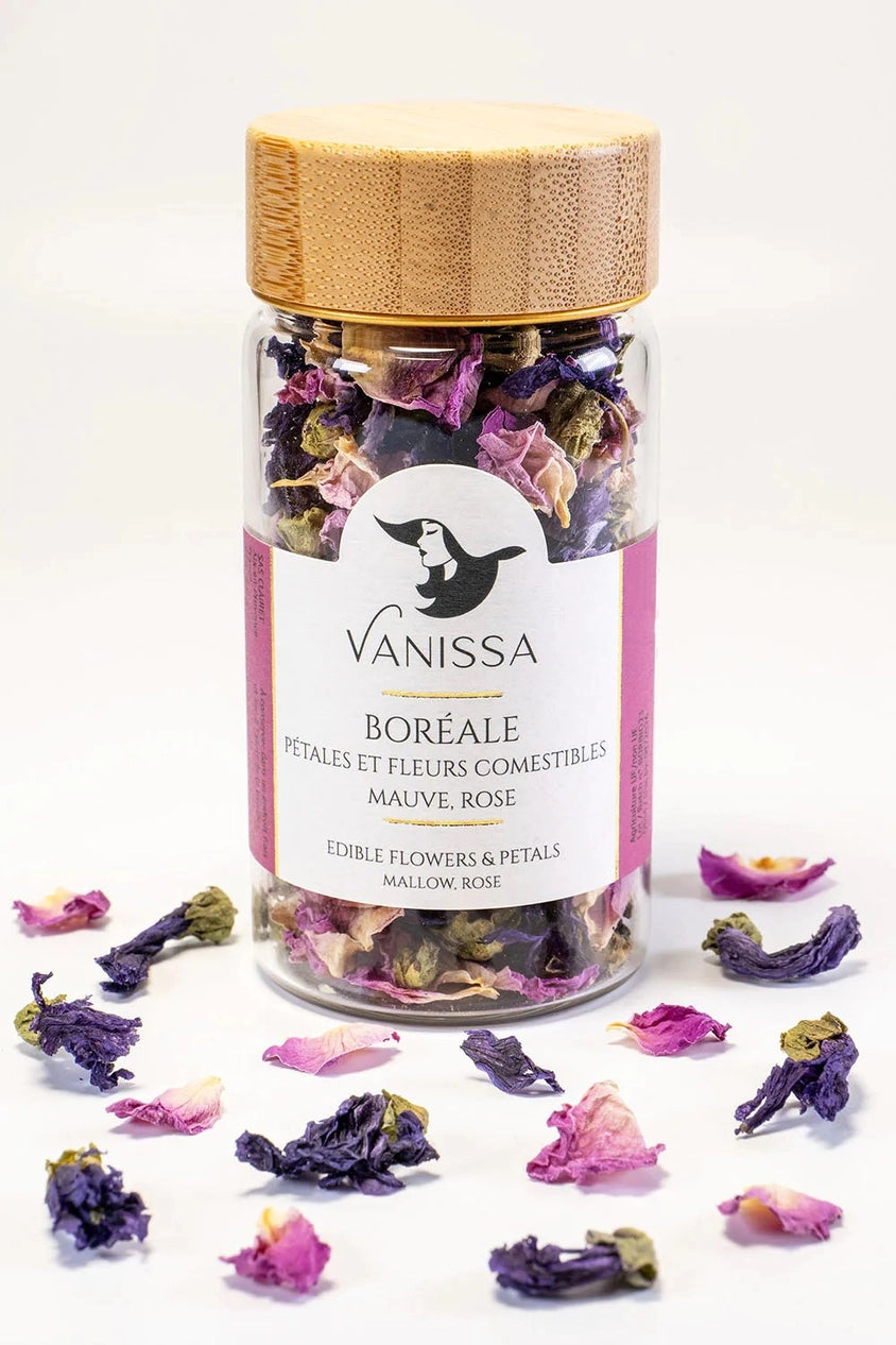 Boreal edible flower petals by Vanissa showing its glass and wood tube packaging and loose petal around it.