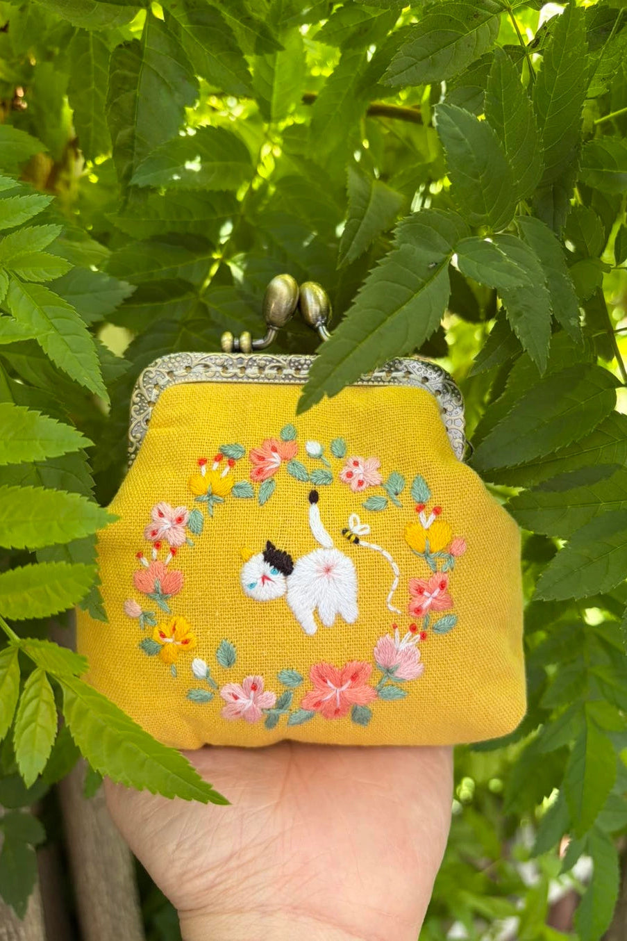 Cat Embroidered Coin Purse being held in front of leaves ©Quince Fables