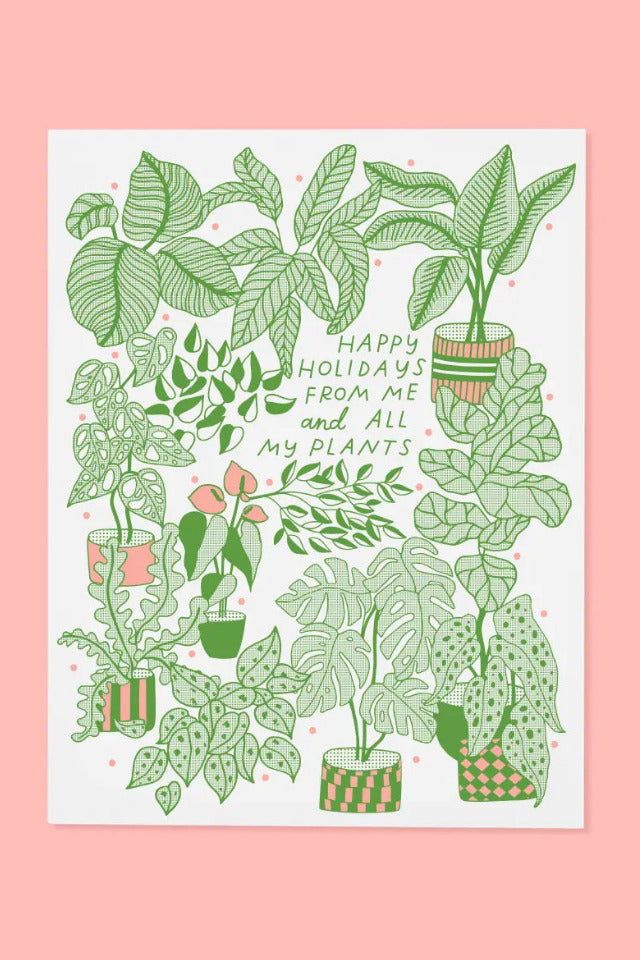Plant Holiday Card featuring hand-drawn green plant illustrations and the text 'Happy Holidays from Me and All My Plants' on a white card, set against a solid pink background. ©The Good Twin