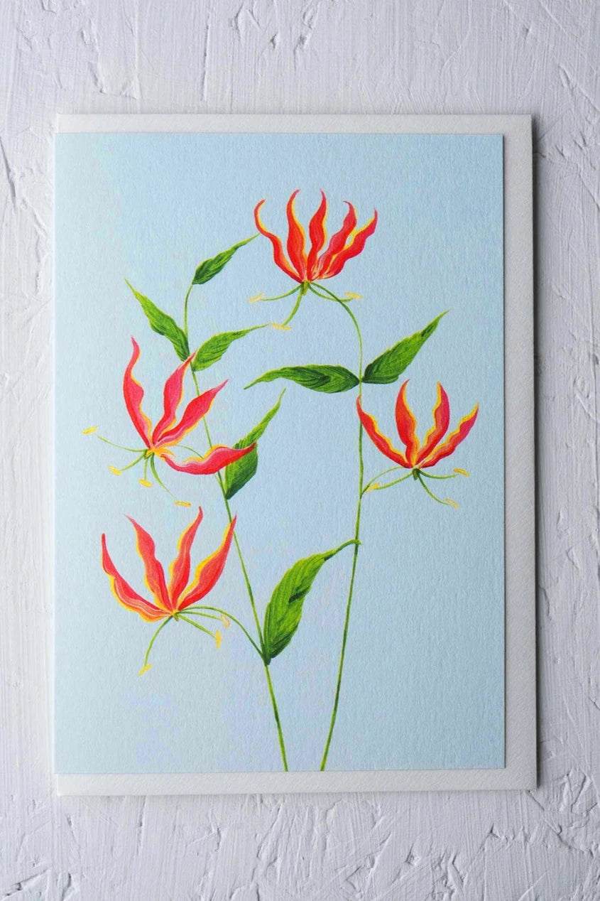 Flame Lily card by Stengun Drawings showing the front of the card with all its color against a white wall. 